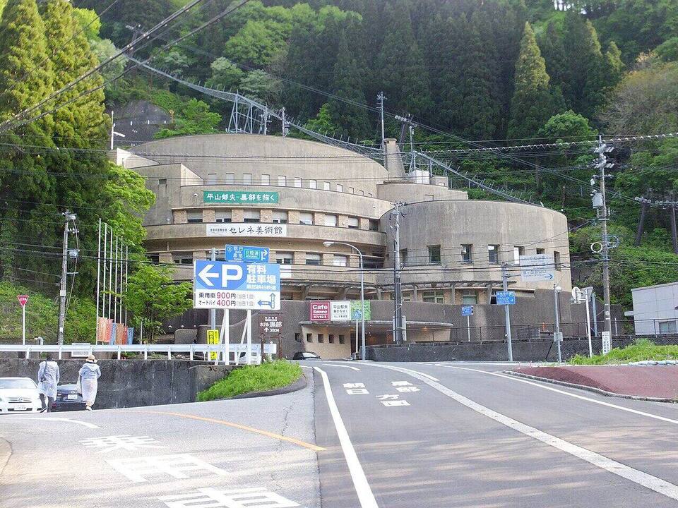 湯けむりの向こうに配された和紙風の案内板と木の格子