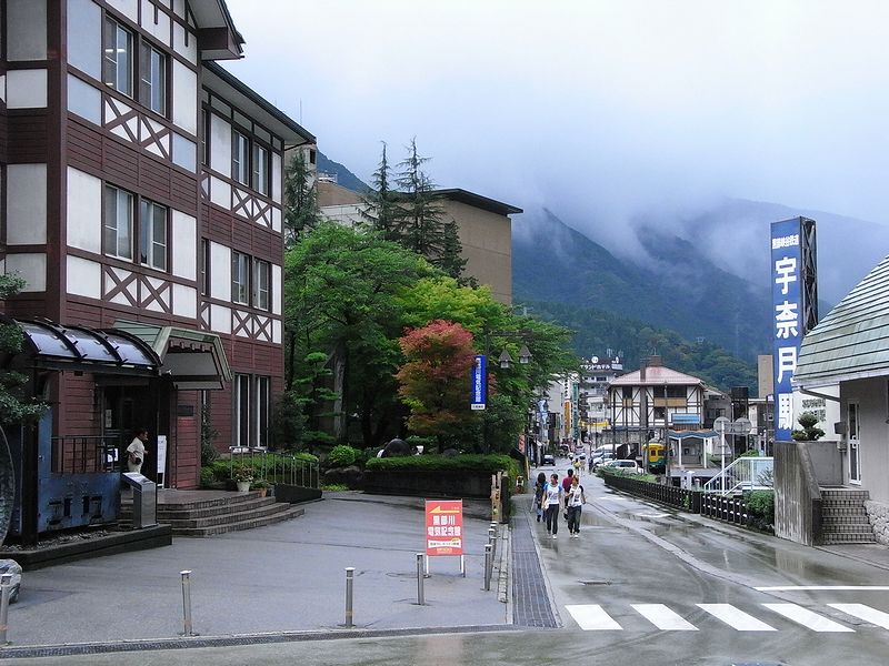 山あいの駅前に続く道と温泉地の建物