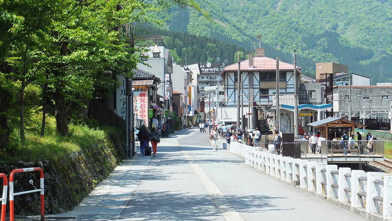 湯けむりの向こうに配された和紙風の案内板と木の格子