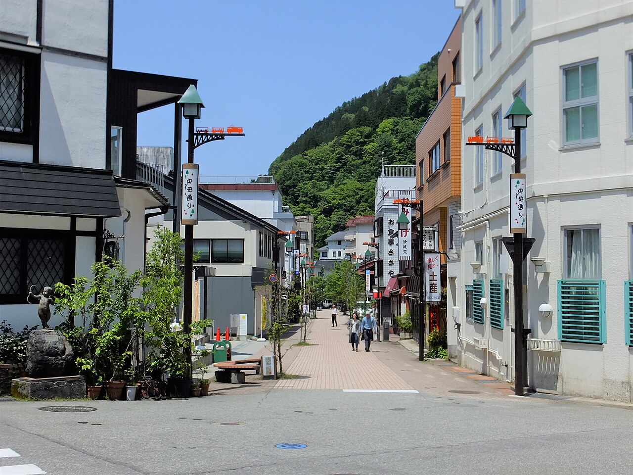 夕闇に滲む橙色の軒灯と、石垣を這う湯気